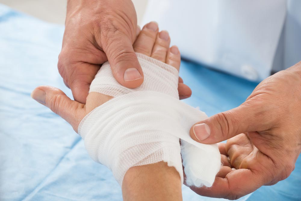 Person Hand Wrapping Bandage To Patient